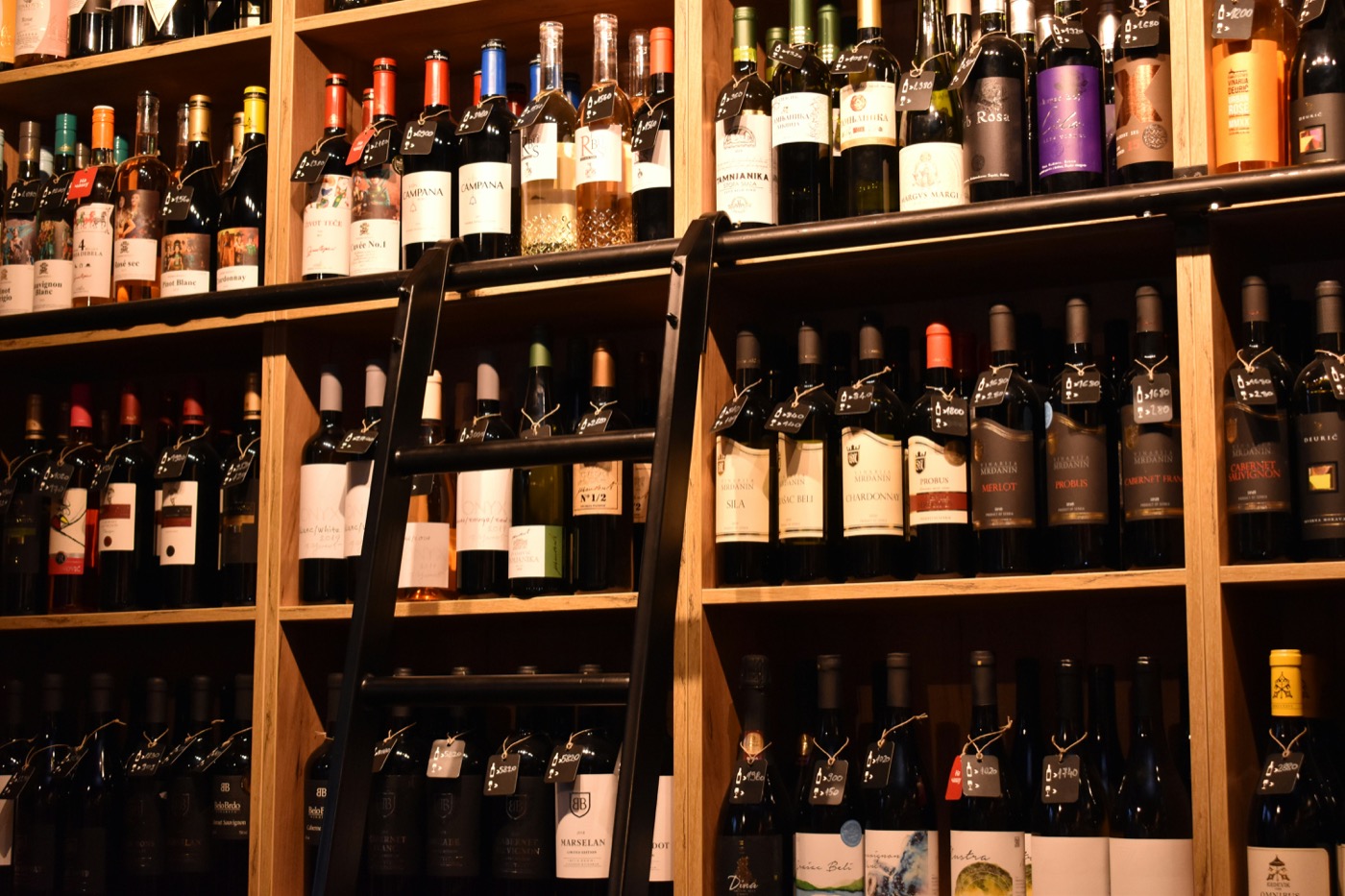 Wine bottles on floor-to-ceiling shelves with warm amber lighting
