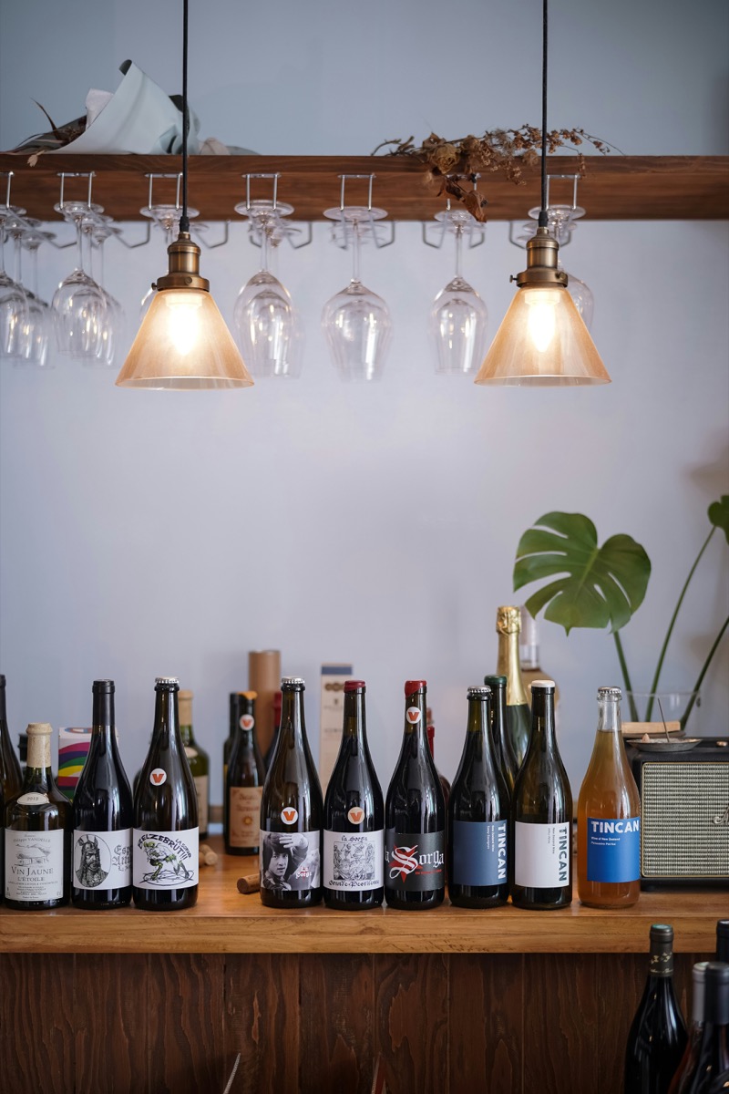 Wine bar counter with bottles and warm pendant lighting